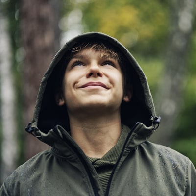 Teen boy with a jacket on in the rain