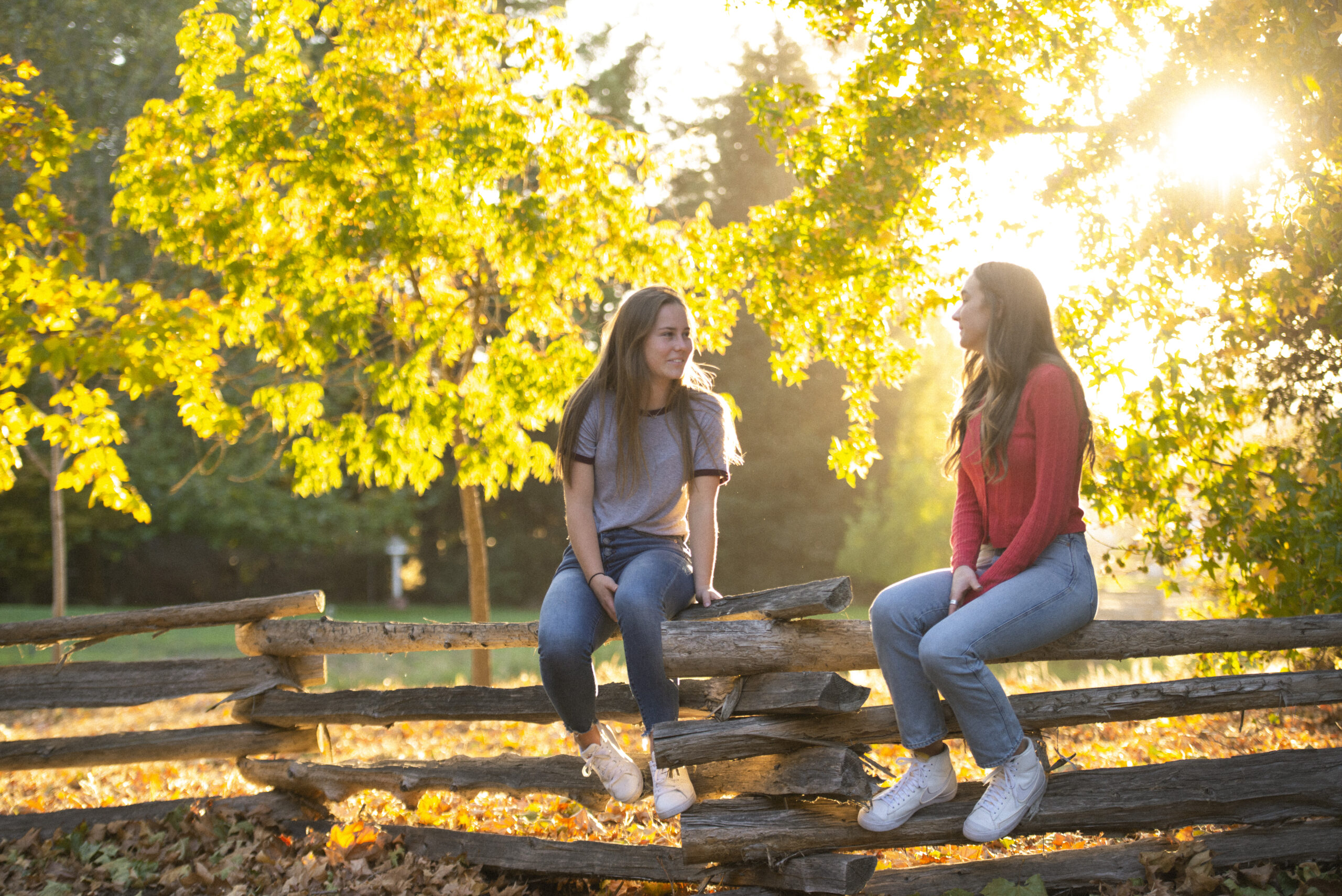 Two teen girls sitting on a fence at Muir Wood Teen Treatment